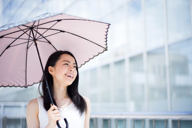 夏は日傘で紫外線対策をする女性